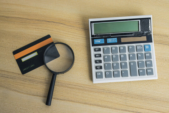 High Angle of Calculator and Magnifier Beside Credit Card