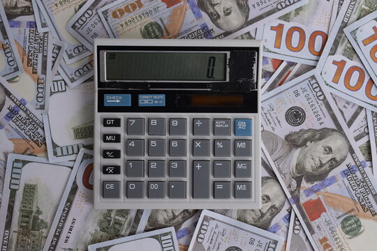 Top View of Calculator Placed on Scattered Dollar Banknotes