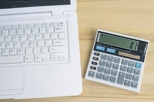 High Angle of Electronic Calculator Placed Beside Laptop
