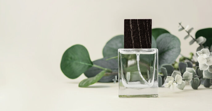 Perfume or glass cosmetic spray bottle with wooden cap with green leaves decoration