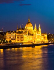 Naklejka premium Golden domed cathedral at dusk with illuminated reflections.