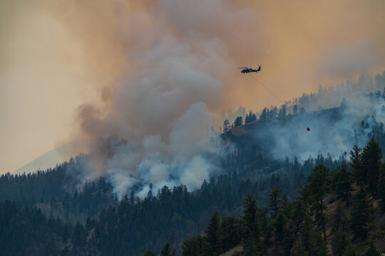 Firefighting helicopter battles smoky mountain wildfire
