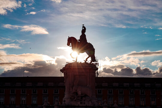 Equestrian statue silhouetted against a dramatic sunset