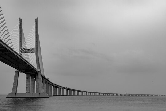 Massive modern bridge curves over calm water
