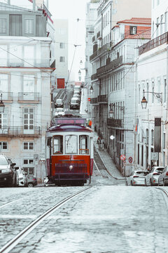 Classic red tram on a steep cobblestone street in Lisbon