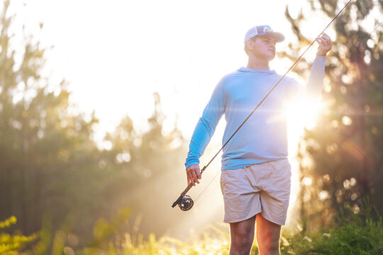 Man fly fishing in early morning sunlight