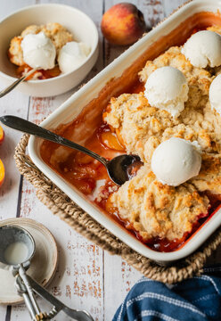 Close up of fresh homemade peach cobbler with vanilla ice cream
