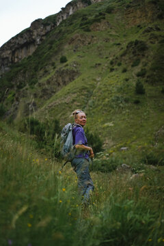 Smiling woman looks back while hiking up a mountain