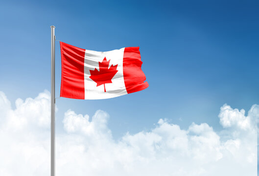 Canada flag waving in beautiful sky.