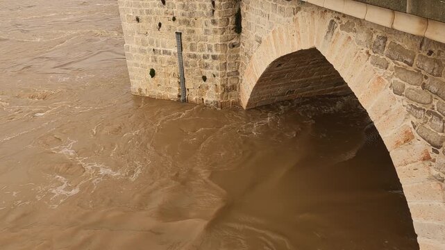 Historic River Gauge Inside Stone Bridge Arch During Winter Flood