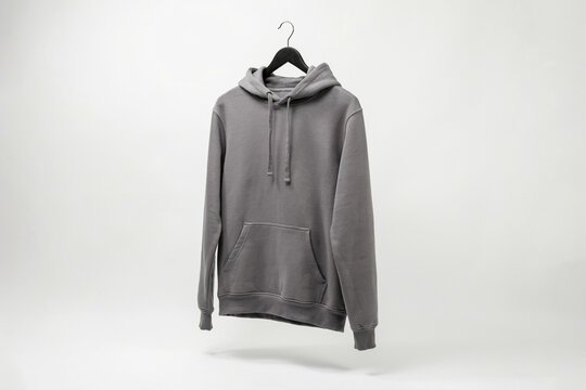Gray pullover hoodie on hanger, minimalist studio product photo on white background with soft shadows for apparel catalog and ecommerce listing