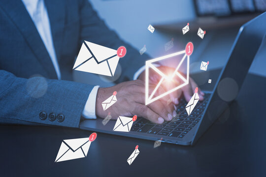 A professional businessman in a sleek suit works diligently on his laptop computer with visuals representing the concept of managing a busy email inbox.