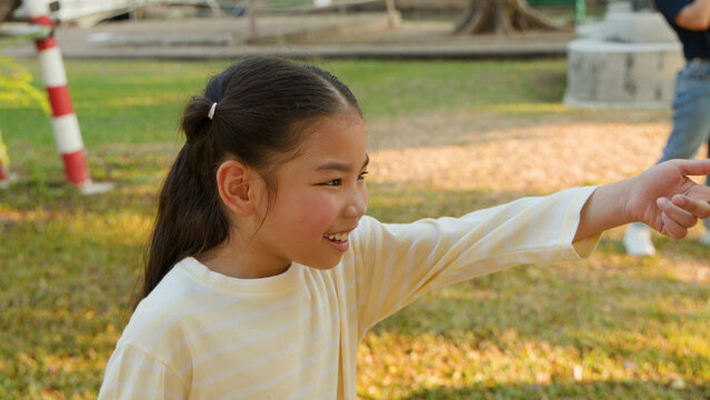 Happy Young Thai Girl Smiling and Pointing in Lumpini Park