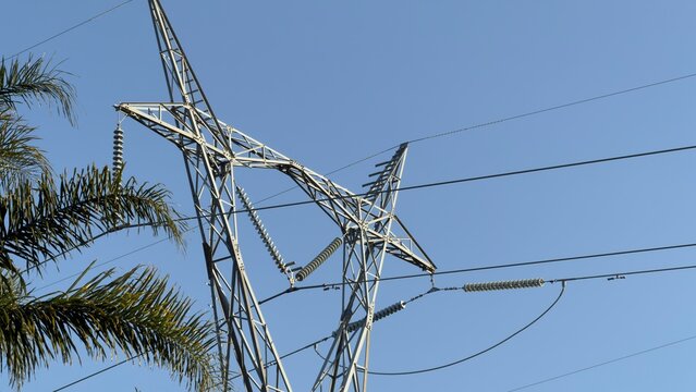 High Voltage Power Line Pylon Against Clear Blue Sky
