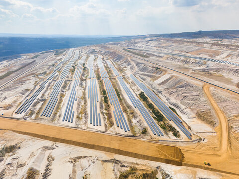 Aerial view of Hambach open pit mine with rows of photovoltaic solar panels installed on reclaimed land for renewable energy generation in Elsdorf, North Rhine-Westphalia, Germany.