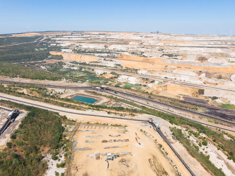 Aerial view of Hambach large open pit mine with extensive lignite excavation, industrial conveyor belts, and large-scale earthworks in Elsdorf, North Rhine-Westphalia, Germany.