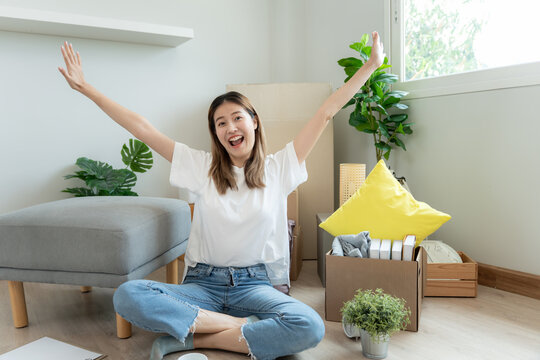 Moving house, relocation. Woman smile and happy after buy new apartment, inside the room was a cardboard box contain personal belongings and furniture. move in the new apartment or condominium