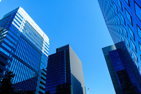 Low angle perspective of corporate headquarters and architecture framing the sky in Marunouchi, Tokyo.