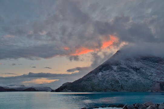 Dramatic clouds over mountains and fjord at twilight