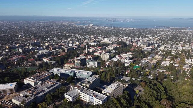 Expansive aerial footage showcasing the University of California, Berkeley campus, with the iconic Sather Tower, and the sprawling cityscape extending towards the distant San Francisco Bay