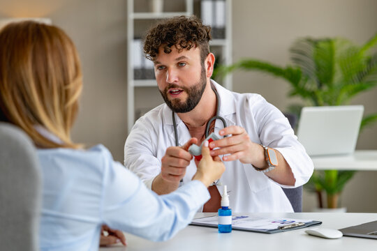 Doctor shows a patient a model while discussing health at a clinic in a modern office setting