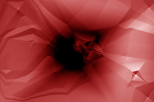 Close up macro shot of a vibrant red flower center showing delicate petals and dark deep shadows