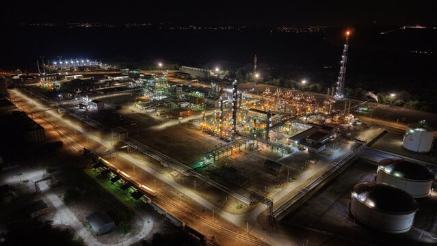Aerial view of the South industrial zone at night, featuring illuminated refinery structures, storage tanks, and complex piping networks in Pancevo, Serbia.