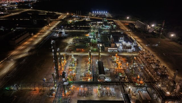 Aerial view of the illuminated Pancevo Oil Refinery in the south industrial zone featuring complex pipe networks, distillation towers, and storage tanks in Pancevo, Serbia.