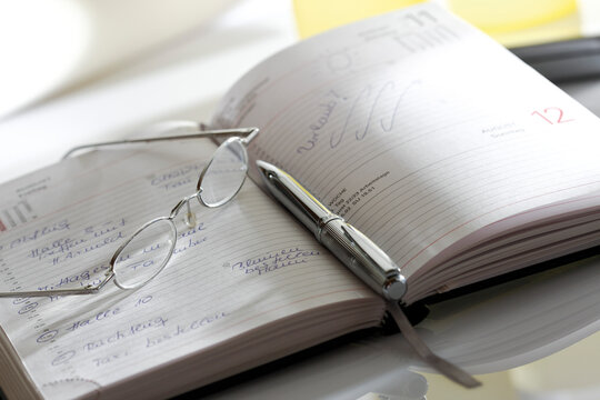 Notebook, eyeglasses and pen, close-up
