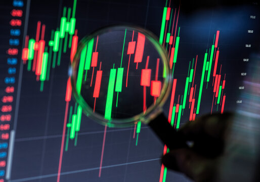 Magnifying glass inspecting stock market volatility on trading chart
