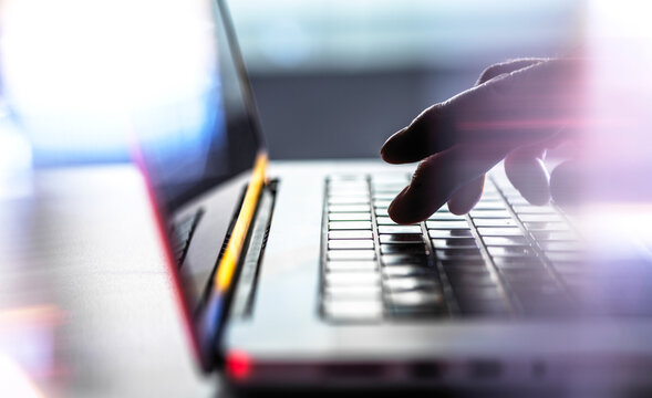 Male hand navigates the internet on a laptop