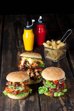 Large hamburger with fries and ketchup and mustard in bottles