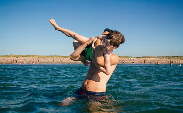 Playful father and son having fun in the sea
