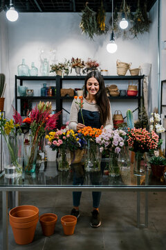 Smiling female florist working at flower shop