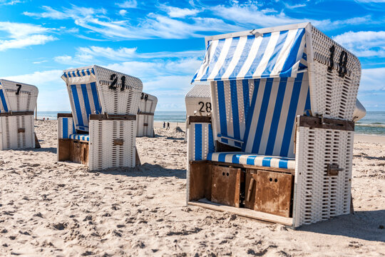 A striped beach chair stands on the sunny sand of Sylt