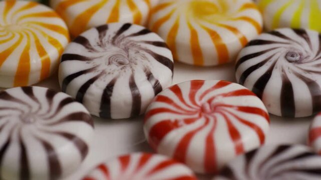 Assorted colorful peppermint swirl hard candies on white surface