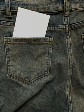 Ripped torn white paper blank note mockup in jeans clothes pocket with a textured denim. Retro minimalist aesthetic background for diy collages.