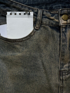 Ripped torn paper blank note mockup in  jeans clothes pocket with a textured denim. Retro minimalist aesthetic background for diy collages.