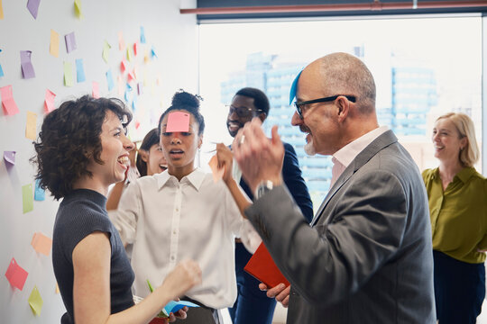 Business team plays a game with an adhesive note at the office