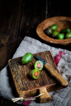 Sliced and whole mini kiwi on wooden chopping board