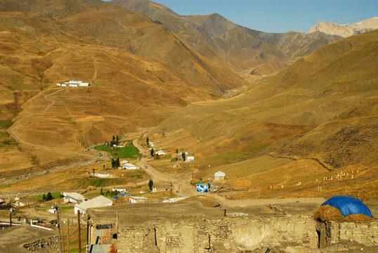 Azerbaijan, Xinaliq, elevated view of village in dry landscape and mountain range