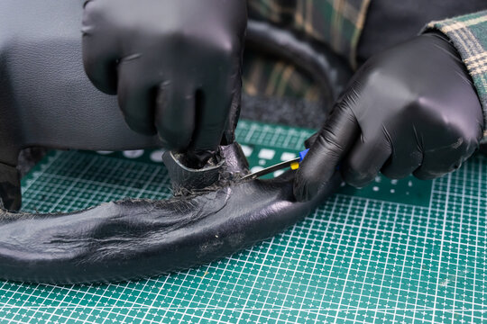 The mechanic changes the cover on the car steering wheel.