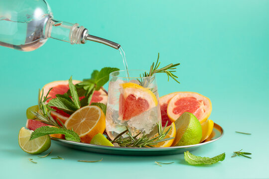 Cocktail with ice, citrus, rosemary and mint.