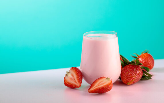 Strawberry yogurt and fresh berries on a colorful background.