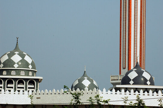 Mosaic domes of a mosque and its minaret, in Africa, with the golden symbols of islam at its top