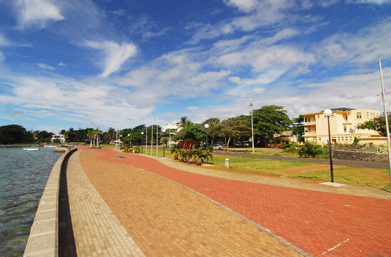 Mauritius, Mahebourg, view of a walkway by sea with nautical vessels in the background against sky