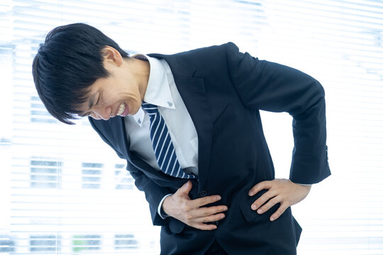 オフィスで腹痛に苦しむビジネスマン