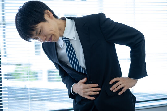 オフィスで腹痛に苦しむビジネスマン