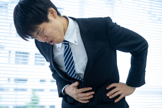 オフィスで腹痛に苦しむビジネスマン