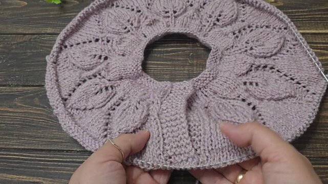 Multicolored hand-knitted fabric. Knitting and crochet lessons. Fashion and education. Training for artificial intelligence. Hands in the frame.